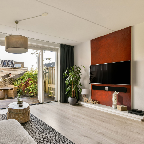 Wohnzimmer-Interieur mit einer auffälligen Akzentwand in Rostoptik, gestaltet mit Rost-Effekt-Paste, einem modernen Ecksofa und einer hellen Fensterfront